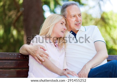 Mature couple hugging on a bench