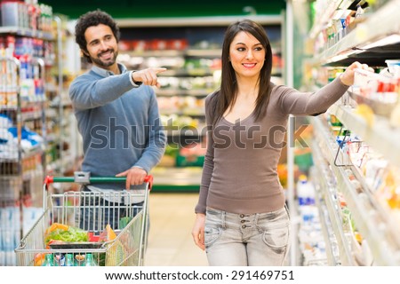 Man asking his girlfriend to buy a product in a supermarket