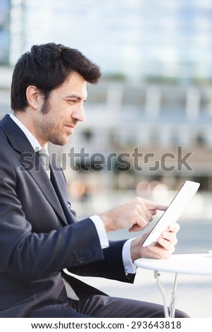 Businessman using his digital tablet during breakfast