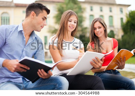 Outdoor portrait of three students studying in a park