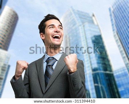 Happy businessman in a victory pose outdoor