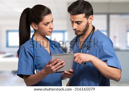 Doctors using a digital tablet in an hospital