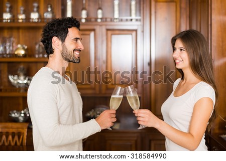 Couple toasting champagne flutes in their apartment