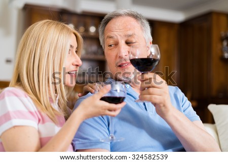 Mature couple toasting wine glasses