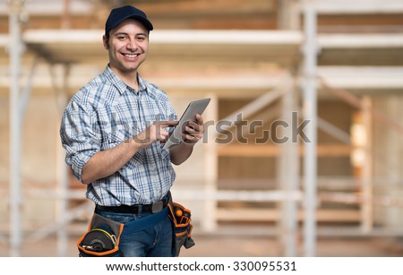 Artisan using his tablet computer in a construction site