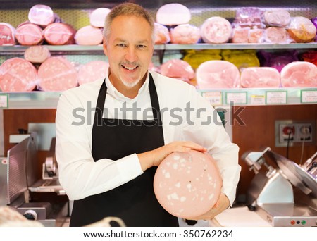 Shopkeeper showing bologna in an italian grocery store