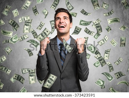 Happy man enjoying the rain of money