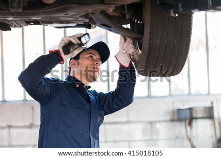 Mechanic inspecting a lifted car