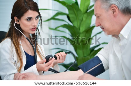 Doctor testing blood pressure to a senior patient