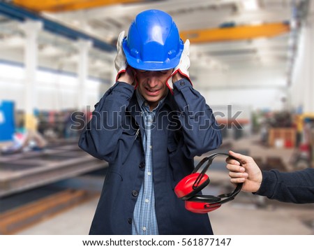 Worker protecting his ears from the noise