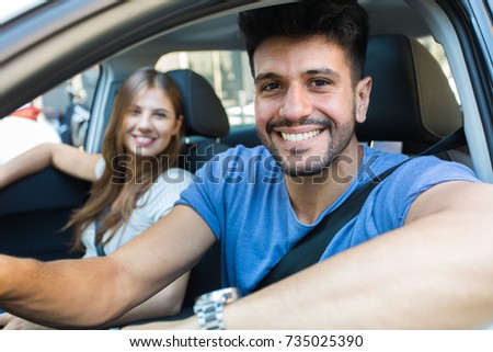 Happy couple driving in a car