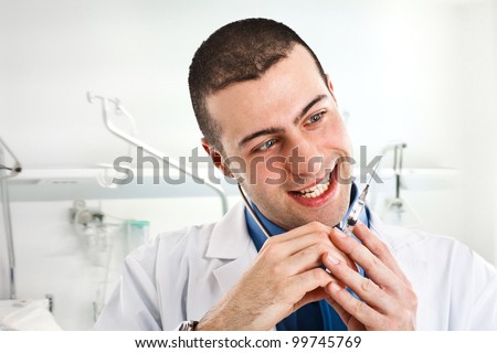 Crazy doctor looking at a syringe