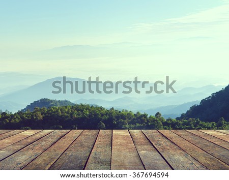 Wood terrace with perspective view on mountain hills and mist. Vintage style.