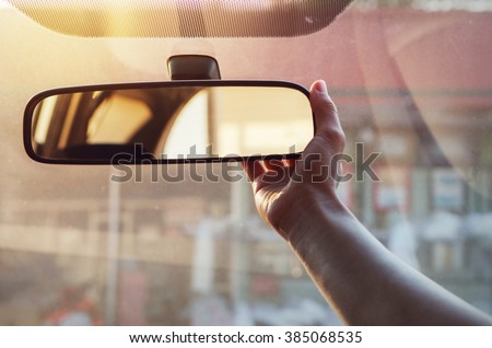 Close up Hand adjusting rear view mirror.