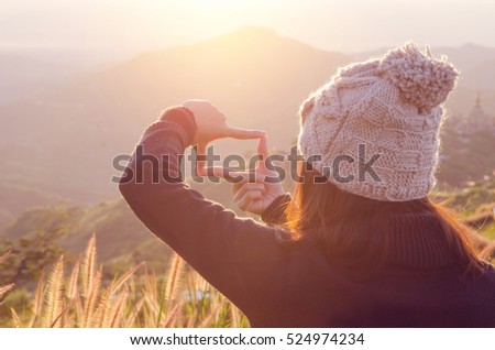 Close up of woman hands making frame gesture with sunrise on moutain and field, Female capturing the sunrise, Future planning, sunlight outdoor.