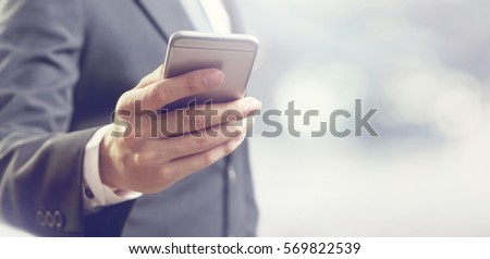 Close up of a business man using mobile smart phone, copy space.