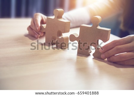 Businesswoman hand connecting jigsaw puzzle on desk, Business solutions, success and strategy concept