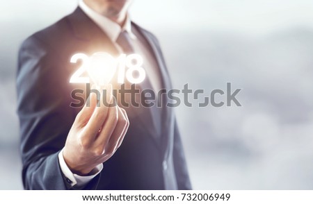 Closeup hand of businessman holding light bulb and number 2018 year, Business idea new year concept. copy space.