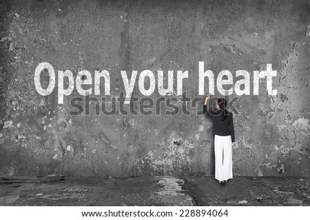 businesswoman drawing open your heart on the wall