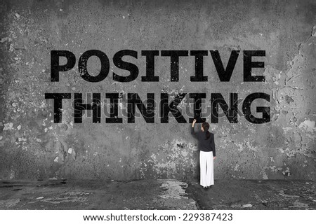 businesswoman drawing positive thinking on the wall