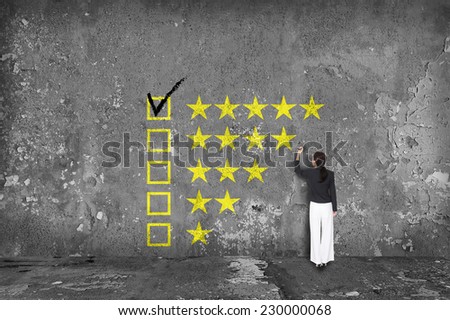 businesswoman drawing rating stars on wall