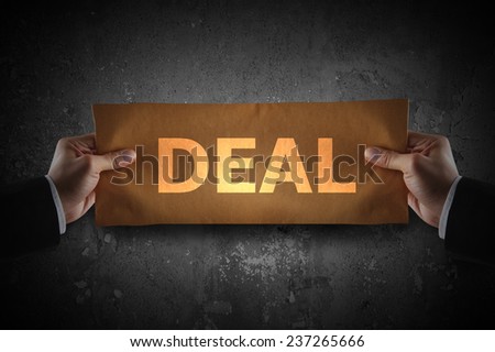 Hand holding sign deal on paper