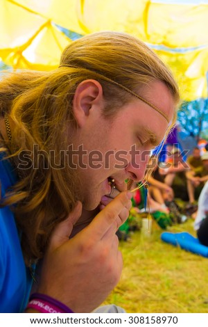 KAZAKHSTAN, ALMATY - AUGUST, 15, 2015: Guy playing mouth harp at sixth ethnic festival FourE