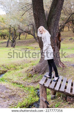 Young blonde girl in the woods near the creek