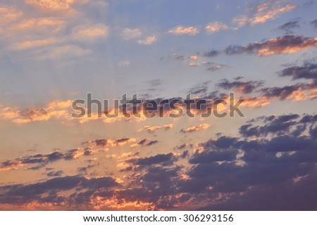 Beautiful cloudy evening sky with sun rays with purple tinge