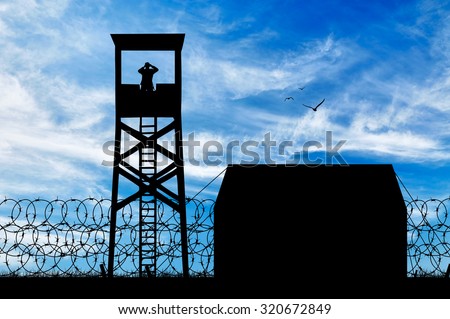 Concept of security. Silhouette of refugee camps and observation towers against the sky