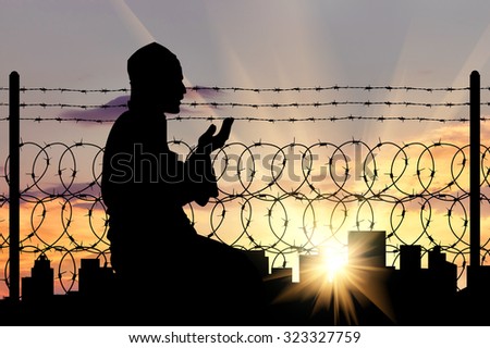 Islamic religion. Silhouette of man praying near the border refugee