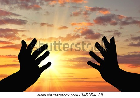 Concept of religion is a refugee. Silhouette of praying hands of an appeal to the sky