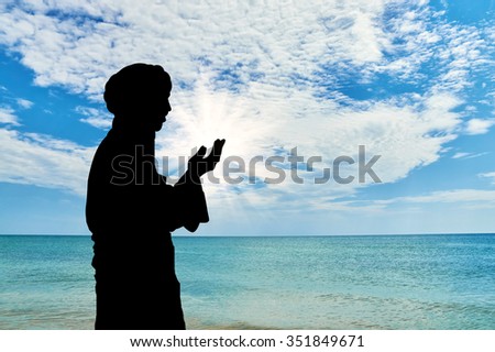 Concept of Islamic culture. Silhouette of man praying on the background of the sea and the beautiful sky