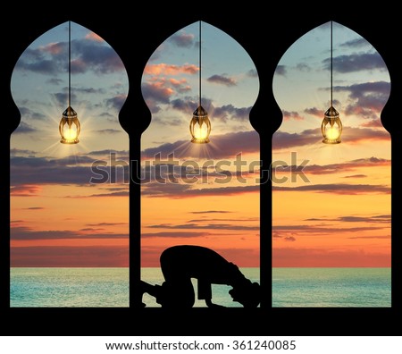 Concept of the Islamic religion. Silhouette of praying Muslim at the background of the sea sunset