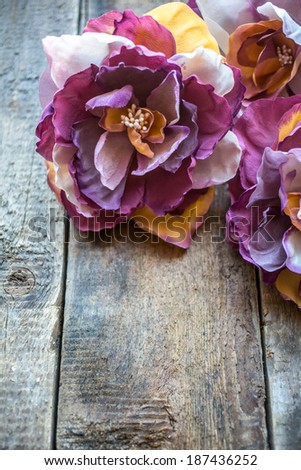Retro handmade flowers on old wooden background. shabby chic