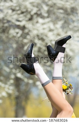 Legs of a happy spring woman in spring park against natural background. Spring vacation, freedom and holiday concept