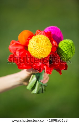 Knitting, flowers and hobby concept, focus on ball of yarn. Creative flower gift for one having passion for knitting