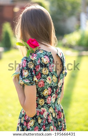 Portrait of a attractive girl with long hair standing outdoors and looking away