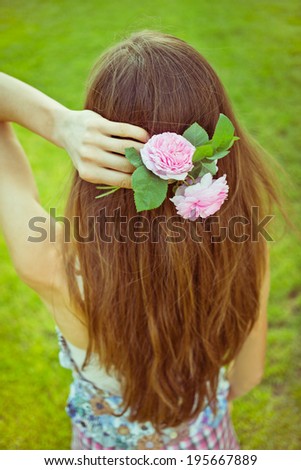 Beautiful young woman with long hair and flower in her hair. toned old image