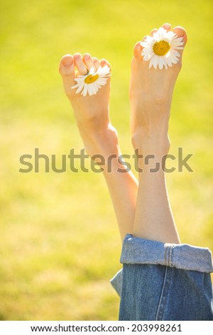 Happy young female legs on a sunny meadow. soft backlight