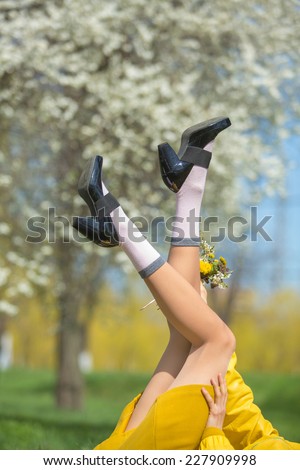 Legs of a happy spring woman in spring park against natural background. Spring vacation, freedom and holiday concept