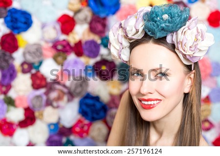 Sensual brunette lady with floral wreath on her head over handmade flower background
