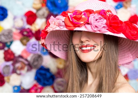 Fashion woman in flower hat over flower background, shadows from hat