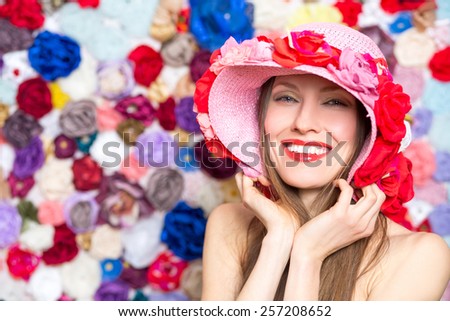 Fashion woman in flower hat over flower background
