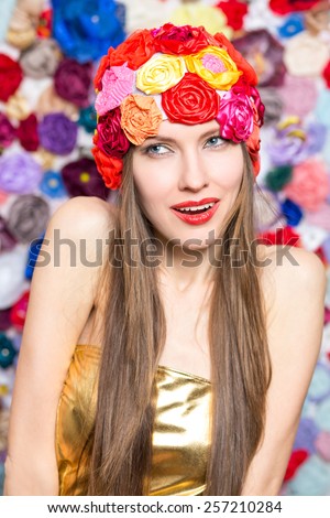 Fashion woman wearing funny summer hat over flowers background. Summer beauty woman concept
