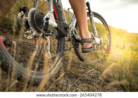 Cyclist riding mountain bike on rocky trail. selective focus on foot and bike details