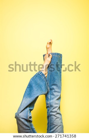 Funny woman legs over yellow background. Summer concept. soft studio shot