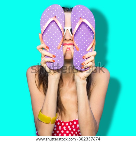 Funny woman with flip flops over vibrant blue background