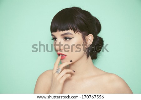 Young Beauty Woman With Fringe, Black Nails And Big Silver Ring Touching Her Lips. Green Background.