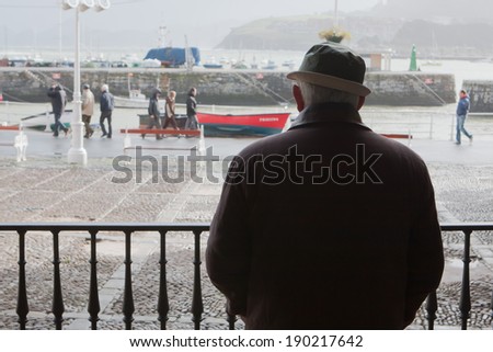 CASTRO URDIALES, SPAIN - JANUARY 24, 2009: Man in the shadow watching the life in town in Castro Urdiales, Northern Spain.